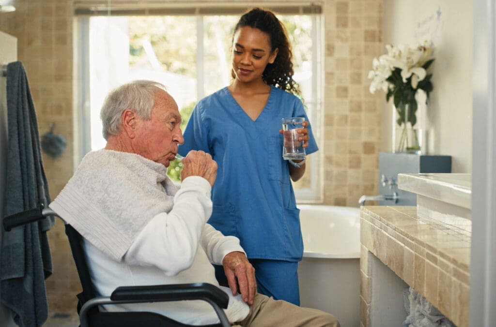 Carer helping a man clean his teeth